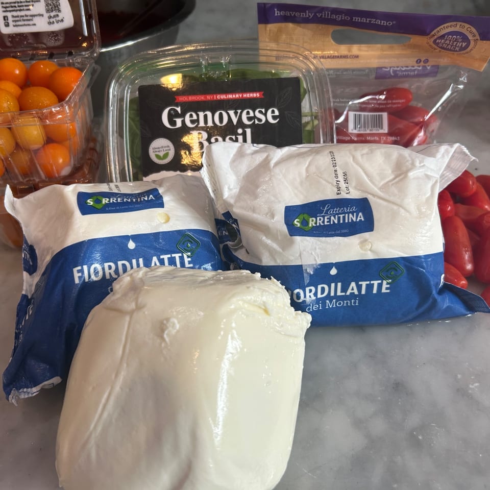 Fresh mozzarella, basil, and tomatoes, ingredients for a Farina 00 pizza.
