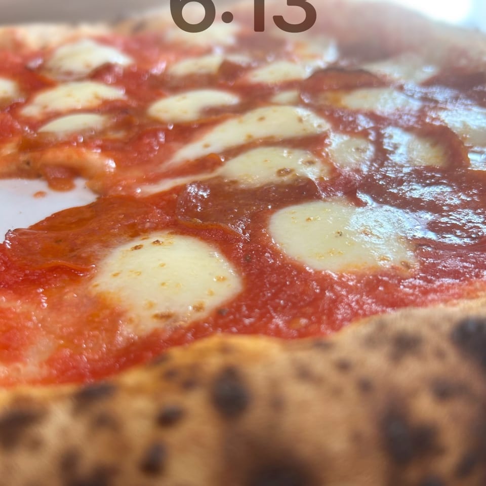 Close-up of a Farina 00 pizza with melted mozzarella and rich tomato sauce.